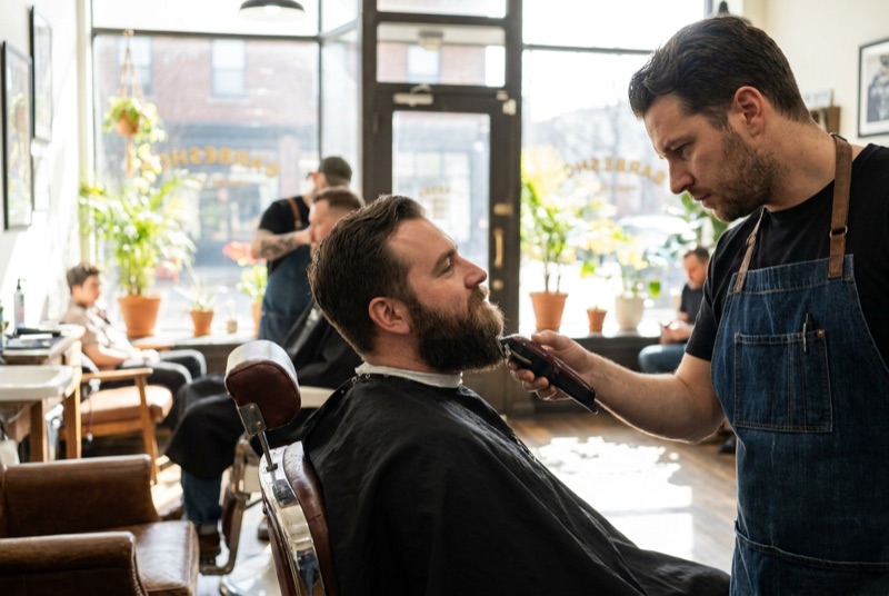 Barbier trimmt einen Bart mit der Maschine